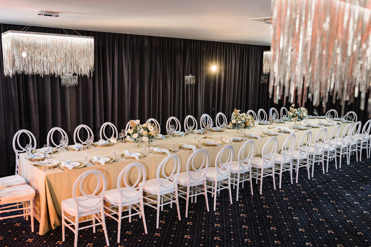 Tri-City Tent Rentals in Schenectady, NY logo - Long table set for a formal dinner